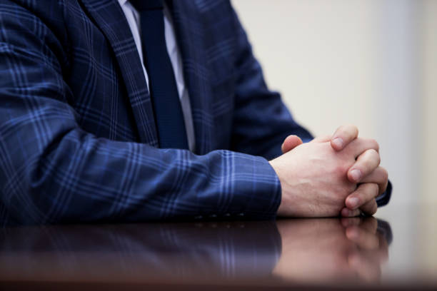 istock A man in a dark suit gesticulates with his hands during a speech 1124420677
