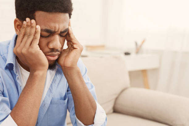 istock African-american man suffering from headache at home 1124421158