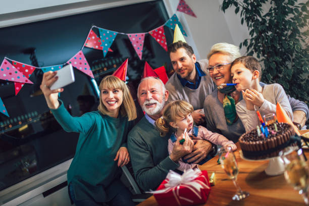 familia celebrando cumpleaños juntos y hacer selfie foto de abuelo. - senior living communitiy fotografías e imágenes de stock