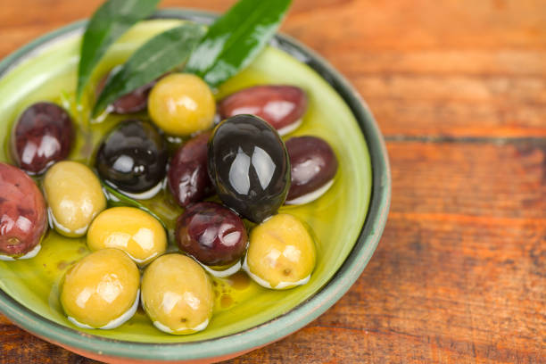 istock Olives in oil on wooden table. 1124425169
