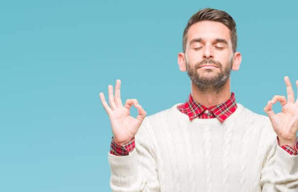 istock Young handsome man wearing winter sweater over isolated background relax and smiling with eyes closed doing meditation gesture with fingers. Yoga concept. 1124426751