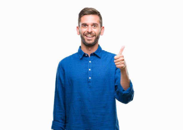 istock Young handsome man over isolated background doing happy thumbs up gesture with hand. Approving expression looking at the camera with showing success. 1124426826