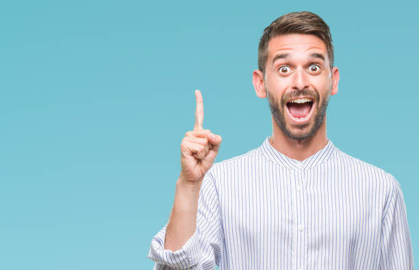 istock Young handsome man over isolated background pointing finger up with successful idea. Exited and happy. Number one. 1124426862
