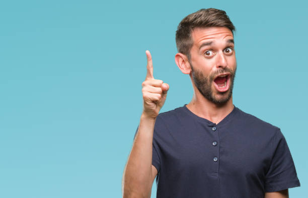 istock Young handsome man over isolated background pointing finger up with successful idea. Exited and happy. Number one. 1124427356