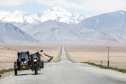 A sidecar motorcycle backed by a mountain range.