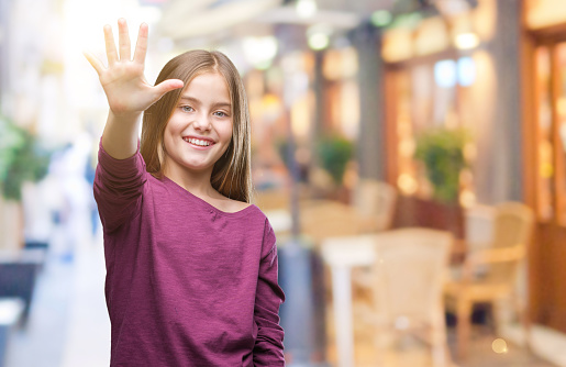 Young beautiful girl over isolated background showing and pointing up with fingers number five while smiling confident and happy.