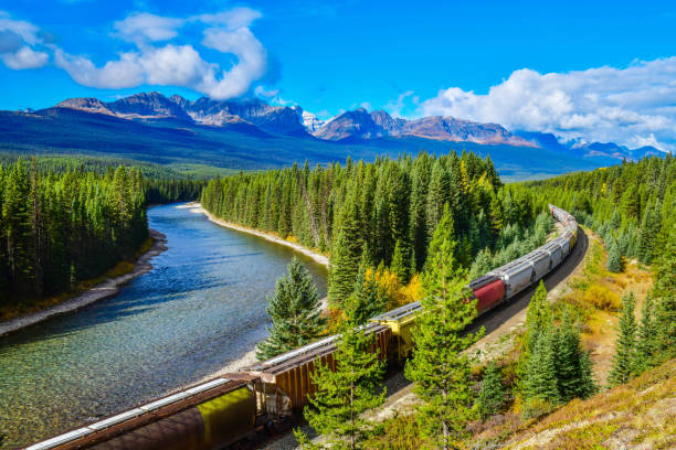 istock Train moving along Bow river in Canadian Rockies 1124430949