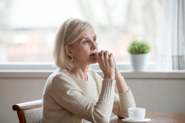 istock Thoughtful woman sitting at table with cup of tea 1124436548