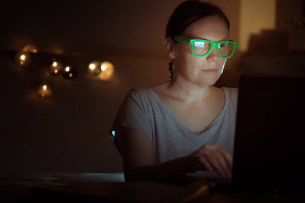 istock Woman working overtime on laptop computer late at night 1124436610