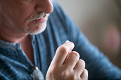 Close up mature man holding in hand pill