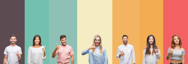 istock Collage of different ethnics young people over colorful stripes isolated background doing happy thumbs up gesture with hand. Approving expression looking at the camera showing success. 1124439282
