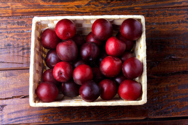 istock raw and fresh organic plums inside rustic fabric wooden box on rustic table. Close-up view 1124439390