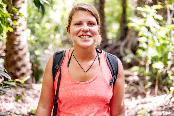 istock Smiling Young Woman Exploring Tropical Forest 1124441750