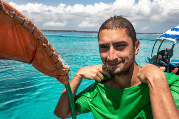 istock Young Smiling Man Having Fun on Boat Trip on Tropical Vacations 1124441764