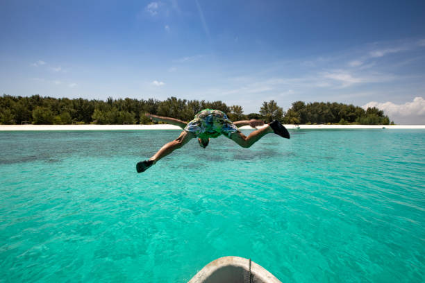 istock Young Man Jumping Off a Boat on Tropical Vacations 1124441779