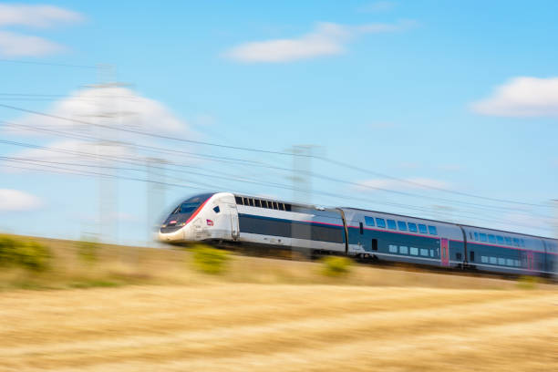 A TGV Duplex high-speed train in Carmillon livery driving at full speed in the french countryside. Varreddes, France - August 18, 2018: A TGV Duplex high-speed train in Carmillon livery from french company SNCF driving at full speed on the East European high-speed line (artist's impression). duplex photos stock pictures, royalty-free photos & images