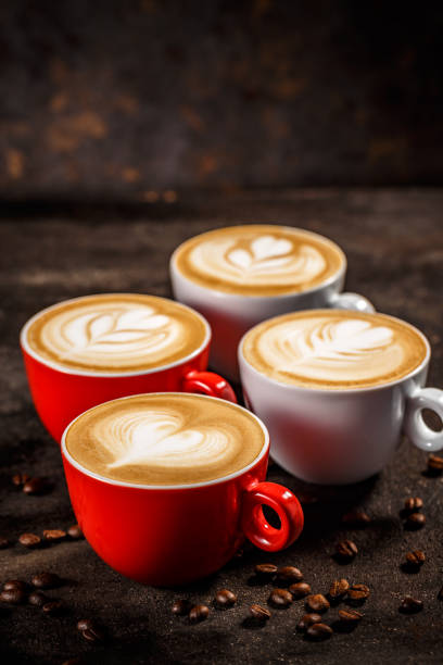 Cups of cappuccino with trendy shapes latte art