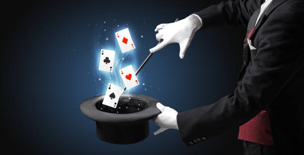istock Magician making trick with wand and playing cards 1124445095