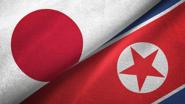 north korea and japan two flags together textile cloth, fabric texture - japanese flag flag japan textile imagens e fotografias de stock