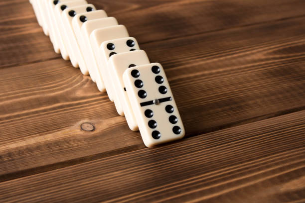 istock Playing dominoes on a wooden table. Domino effect 1124457241
