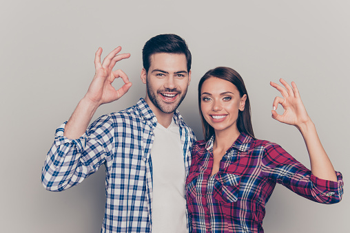 Close up photo of she her he his handsome beautiful pretty attractive trendy nice glad optimistic married spouses make give double okey signs isolated grey background