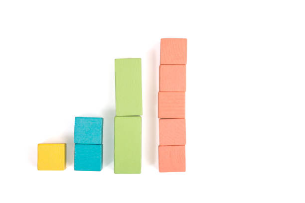 istock Toy wooden blocks as financial graph. Graph with four 4 steps. Growing chart. Infographic diagram, chart over grey or black or dark background. Multi-colored wooden blocks. 1124463314