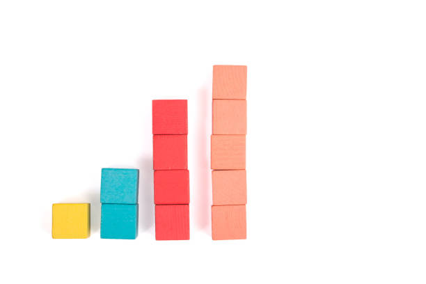 istock Toy wooden blocks as financial graph. Graph with four 4 steps. Growing chart. Infographic diagram, chart over grey or black or dark background. Multi-colored wooden blocks. 1124463405