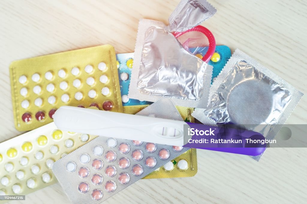 contraceptive birth control pills and condoms on the table wooden background with Leave space for text. concept Safe Sex nothing can happen. Advice Stock Photo