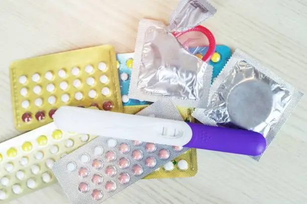 Photo of contraceptive birth control pills and condoms on the table wooden background with Leave space for text. concept Safe Sex nothing can happen.