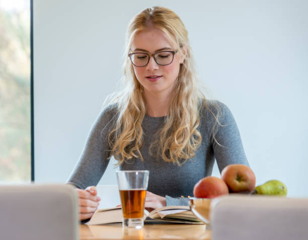 istock Girl drinking hot tea and reading book 1124471886