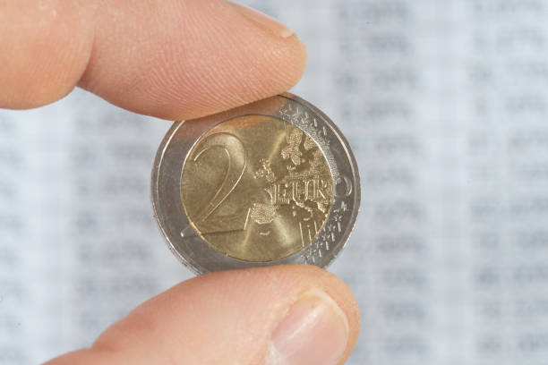 istock A man holds a euro coin in front of a chart 1124474141