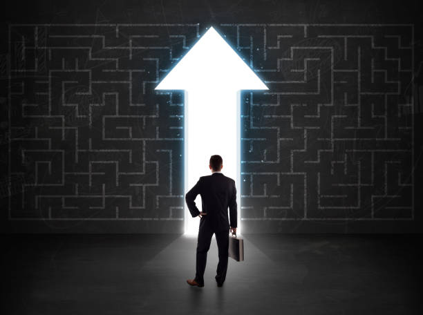 istock Business person looking at maze with solution arrow on the wall 1124474956