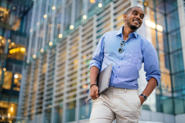 istock Black businessman downtown holding laptop 1124475007