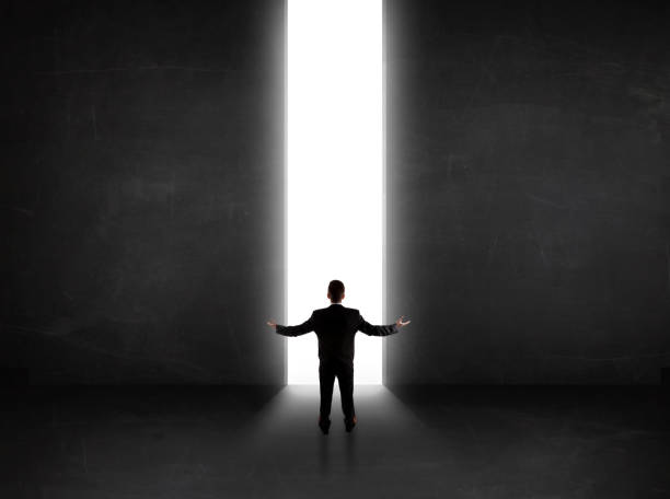 istock Business person looking at wall with light tunnel opening 1124475052