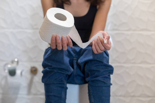 donna seduta in bagno - toilet paper foto e immagini stock