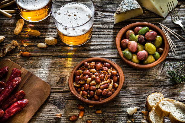 olives, peanuts and beer shot from above on rustic wooden table - beer nuts imagens e fotografias de stock
