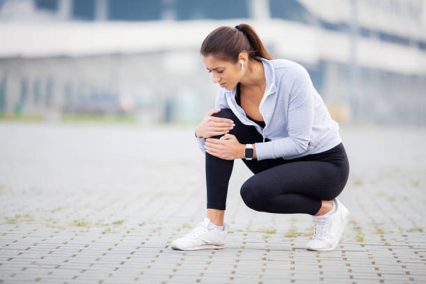 fitness. atletiska kvinnor hålla knä med ett trauma - runner holding legs bildbanksfoton och bilder