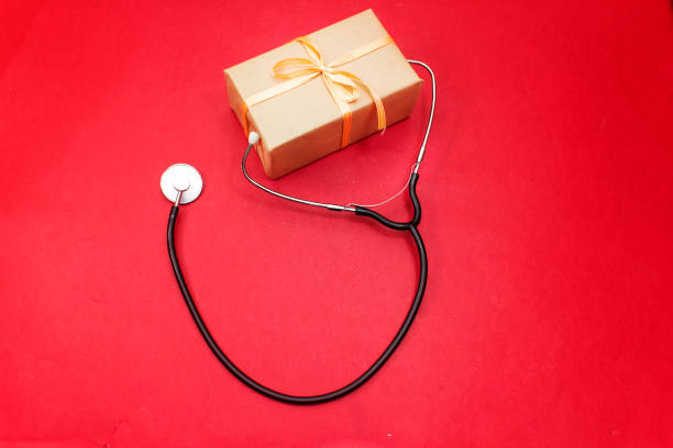 istock Medical stethoscope with red gold gift box on white background. 1124478702