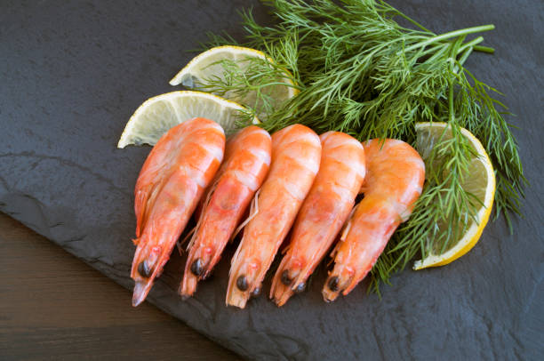 istock Fresh heart-shaped shrimp on a black Board. 1124479413