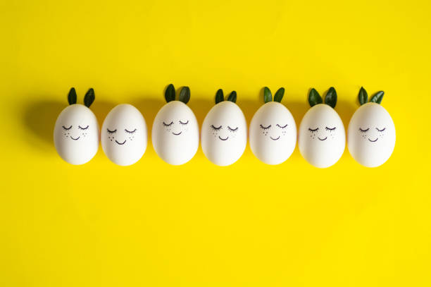 istock Happy Easter card. Cute Easter eggs with a painted face in a spring leaves on yellow background. Happy Easter 1124479738