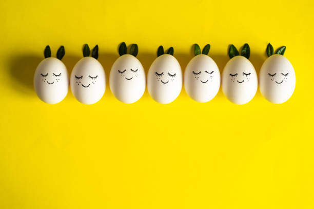 istock Happy Easter card. Cute Easter eggs with a painted face in a spring leaves on yellow background. Happy Easter 1124479821