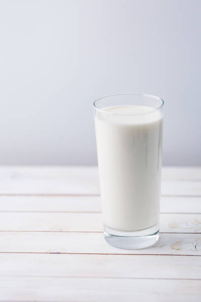 istock Glass of milk on white rustic wooden background 1124481681