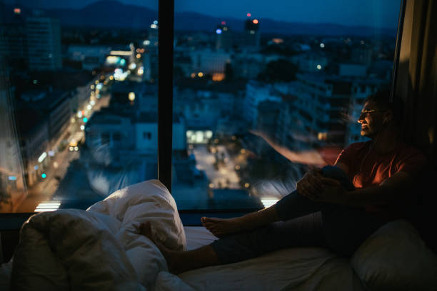 istock Man sitting by the window looking at city 1124485265