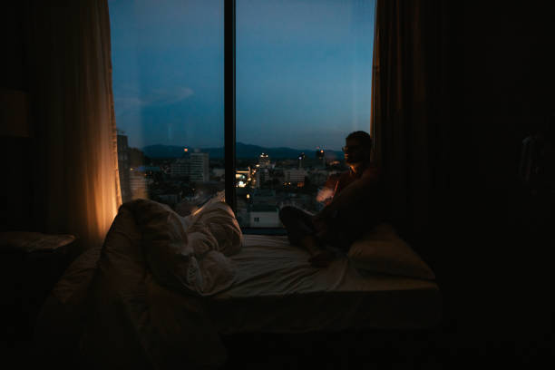 istock Man relaxing by the window at night alone 1124485461
