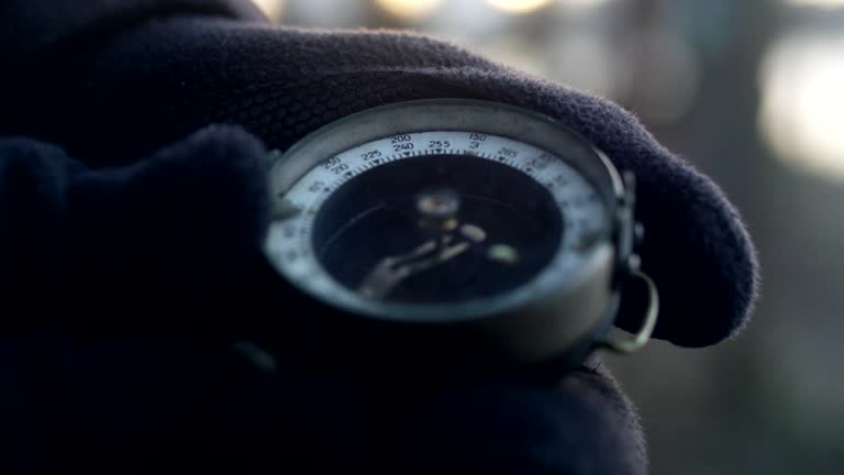 Woman wearing gloves holding compass. Planning trip