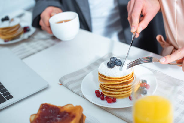 istock partial view of woman cutting pancakes during breakfast in kitchen 1124486239