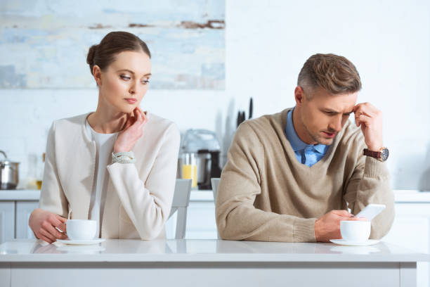 istock dissatisfied man using smartphone and ignoring woman during breakfast in kitchen 1124486364