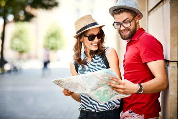 istock Young couple looking at map while on vacation during summer together 1124489159