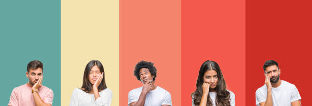 istock Collage of different ethnics young people over colorful stripes isolated background thinking looking tired and bored with depression problems with crossed arms. 1124489892