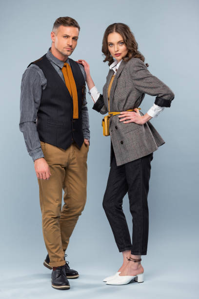 istock beautiful stylish couple in formal wear looking at camera while posing on grey background 1124491273